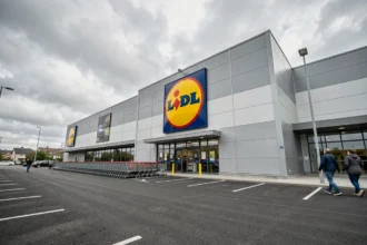 Façade d'un magasin Lidl avec le logo circulaire jaune rouge et bleu bien visible sur la devanture moderne