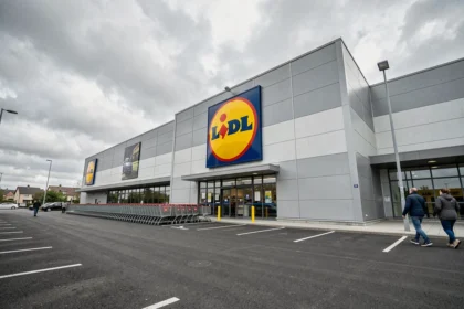 Façade d'un magasin Lidl avec le logo circulaire jaune rouge et bleu bien visible sur la devanture moderne